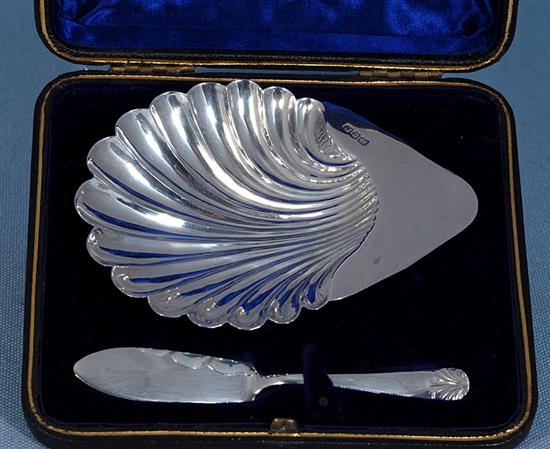 A cased Victorian silver scallop shaped butter dish and knife and a pair of butter dishes, 74 grams.